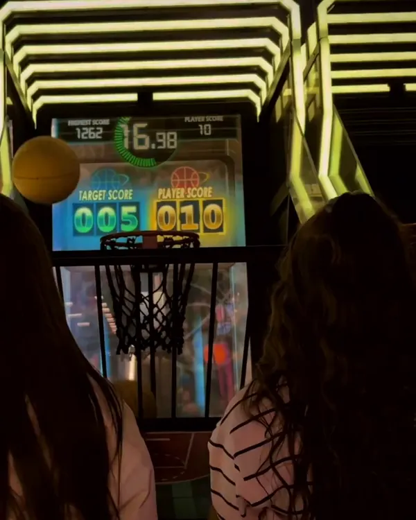 Amigas jogando lado a lado nas cestas de basquete
